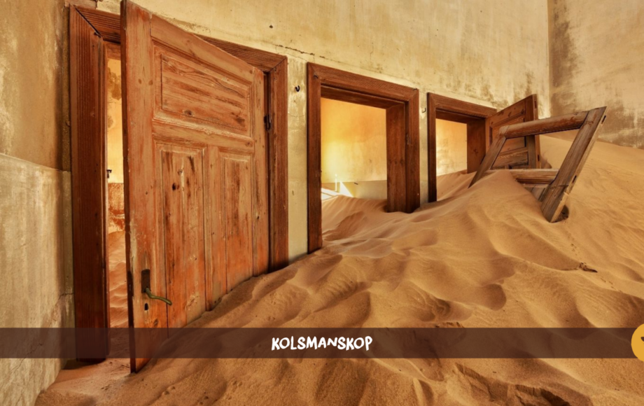 A room with three doors in Kolmanskop with a sand dune inside of it