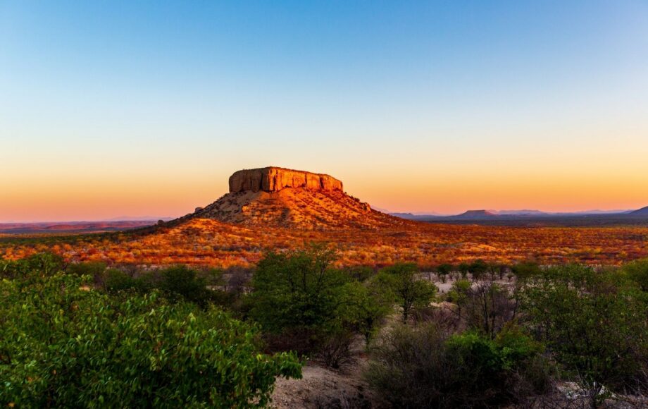 Waterberg Plateau Namibia with sunlit mountain and trees on the ground in front